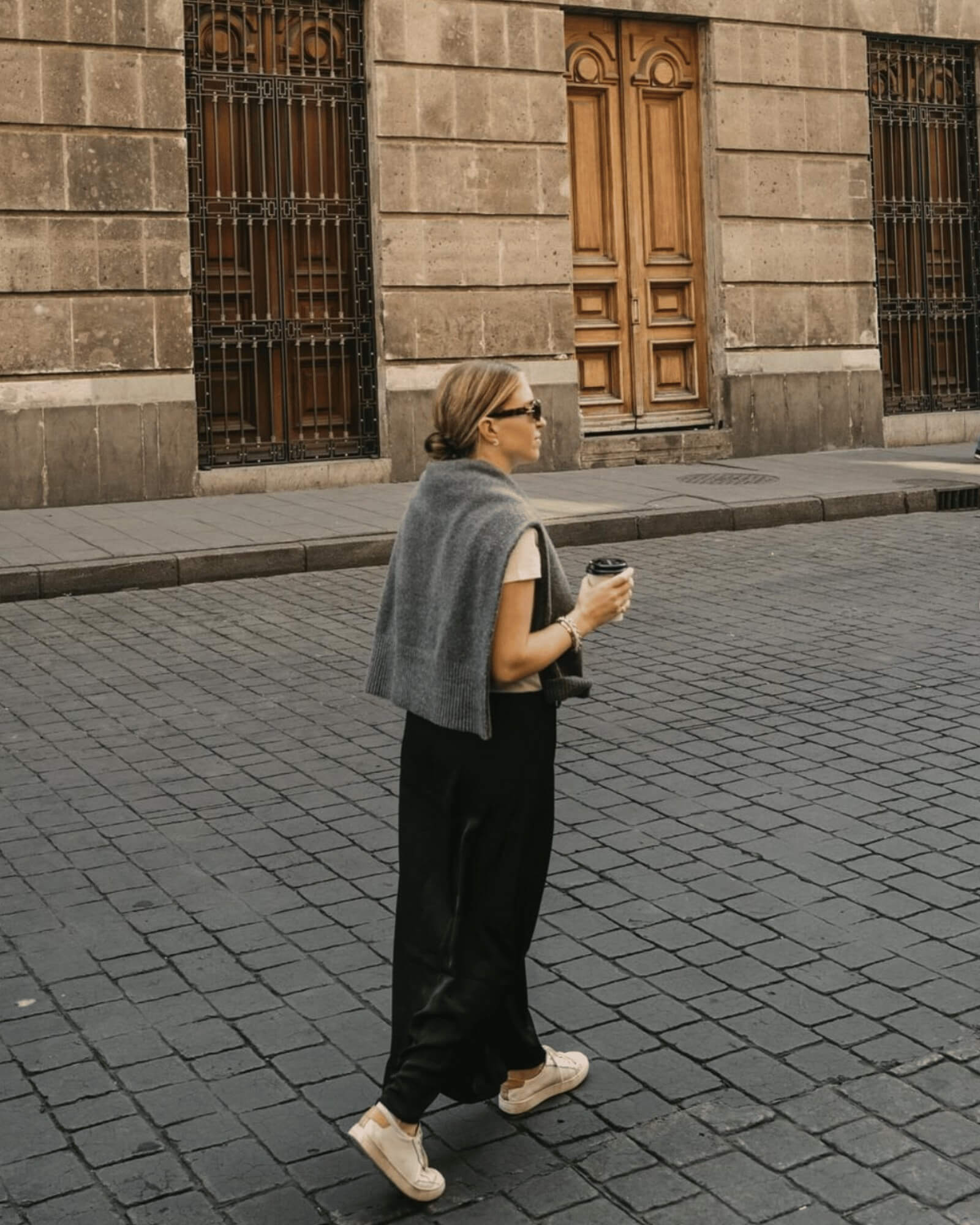 woman walking away from camera in black dress and white Ibiza Sneakers