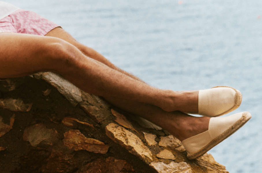 man wearing white shoes by the water